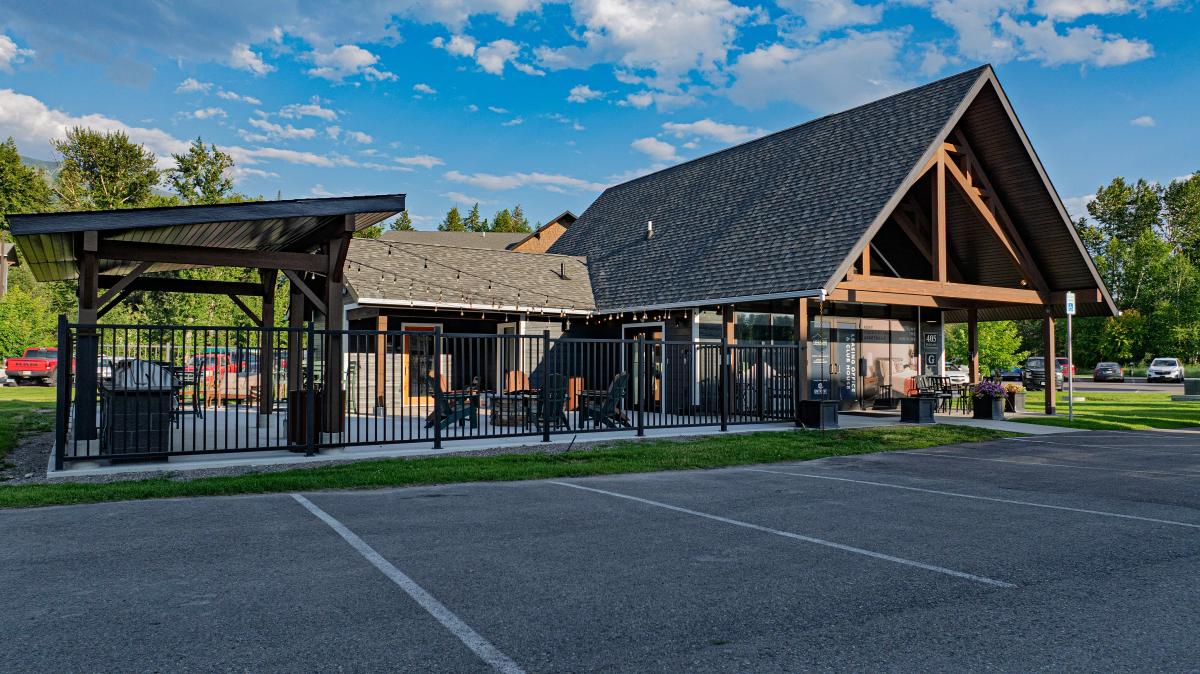 Charming community center with rustic architecture, outdoor seating area, and vibrant greenery backdrop.