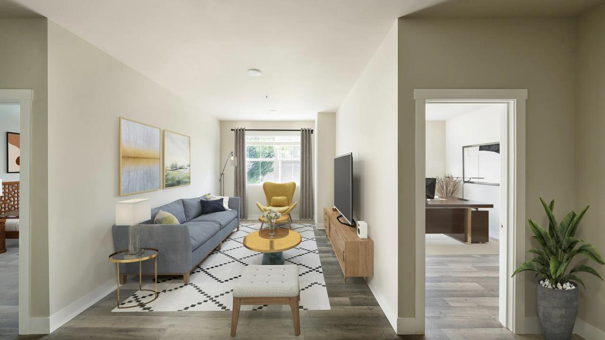 Chic living room with modern decor, featuring a cozy gray sofa, stylish yellow chair, and large flat-screen TV.